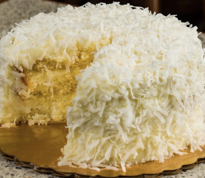 Moist coconut cake made with fresh coconut milk juice and grated coconut flakes soft tropical bakery dessert with rich coconut flavor